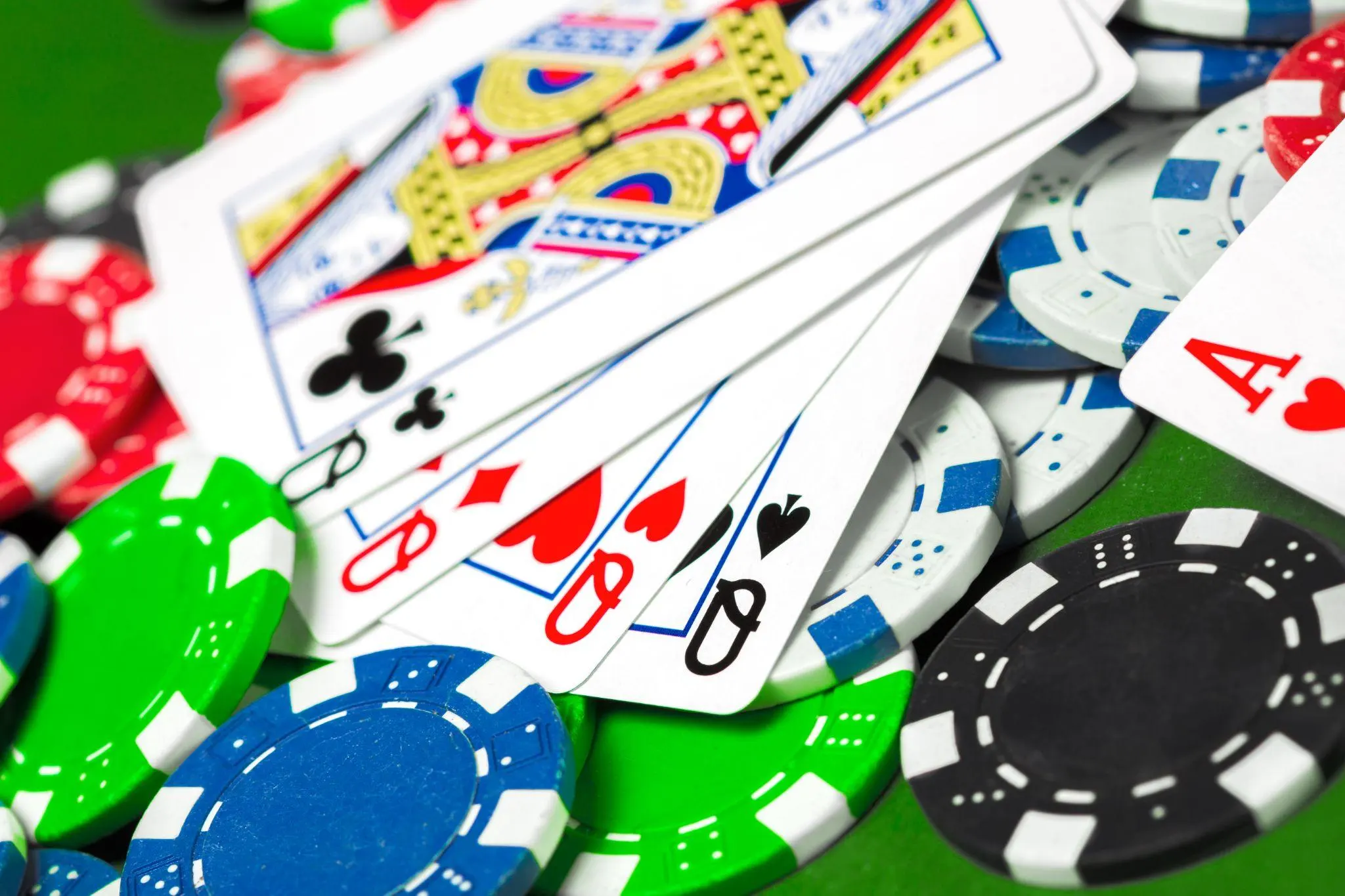 Spillekort og fargerike pokerbrikker på et casinobord